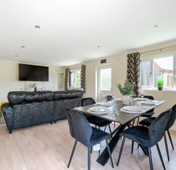 A living room with a sofa and dining table at Poker Lodge Near Brigg