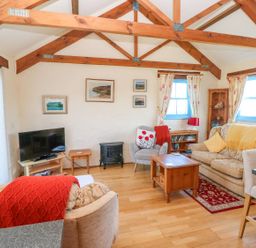 A living room with a tv and sofa at Casa Mia Goodwick