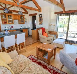 A living room with a kitchen area and seating at Casa Mia in Goodwick