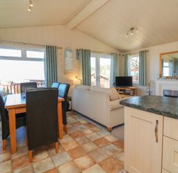 A living room with a dining area and sofa at 1 Ocean Terrace in Ilfracombe