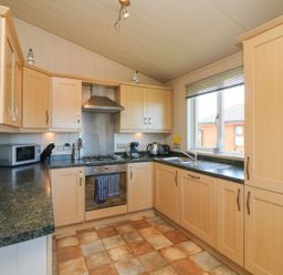 A kitchen with cabinets and appliances at 1 Ocean Terrace in Ilfracombe