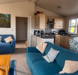 A living room with couches and kitchen area at 1 Ocean Terrace Mullacott near Ilfracombe