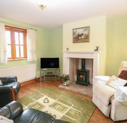 A living room with a fireplace and couch at Mabby in Caister-On-Sea