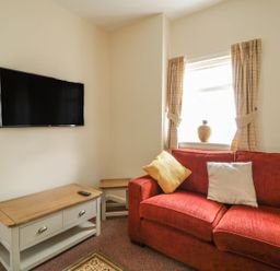 A living room with a television and sofa at No 8- Farmhouse Retreat in Keswick
