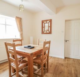 A dining room with a wooden table and chairs at No 8- Farmhouse Retreat in Keswick