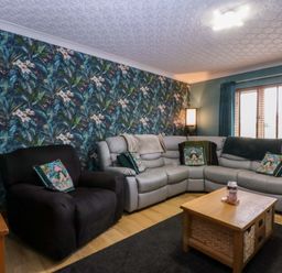 A living room with a sectional sofa and coffee table at 36 Cae Rhos in Holyhead