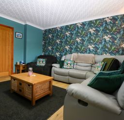 A living room with a sofa and coffee table at 36 Cae Rhos in Holyhead