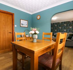 A dining room with a table and chairs at 36 Cae Rhos in Holyhead