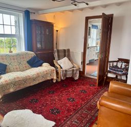 A living room with a sofa and an armchair at Penpegws near Aberystwyth