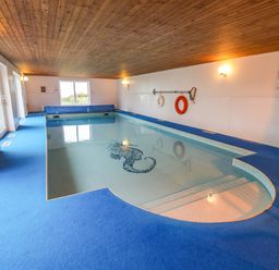 An indoor pool with steps and a lifebuoy at Cliff Cottage