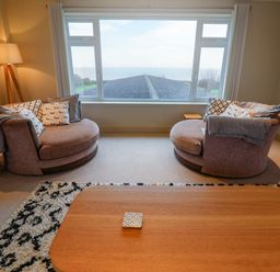 A living room with two sofas and a table at Cliff Cottage