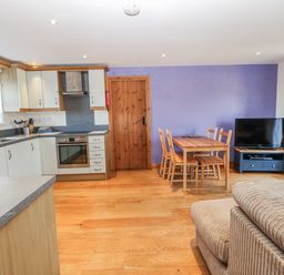 A kitchen with dining area and television at Swallows Rest in Hexham
