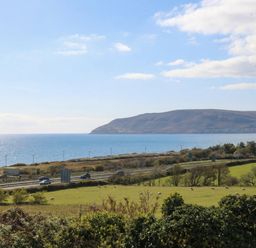 A coastal view with a road and hills at Orme View in Penmaenmawr