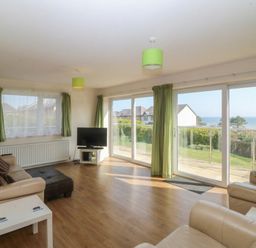 A living room with a sofa and TV at Orme View in Penmaenmawr
