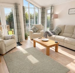A living room with a sofa and armchairs at Tiggywinkle Beck - White Cross Bay in Windermere