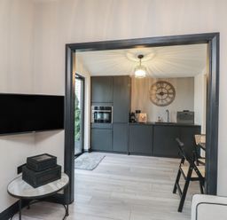 A kitchen with modern appliances and a television at Caban Tan Y Ffawydd Chwilog near Y Ffor