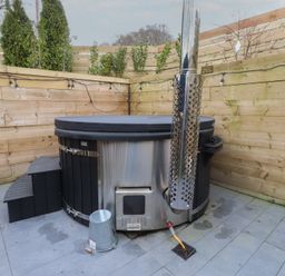 A hot tub on a patio in an outdoor area at Riverside Lodge Afonwen