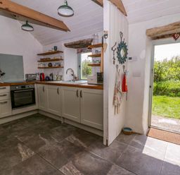 A kitchen with cupboards and a view to the outside at Rhos Y Clegyrn Goodwick