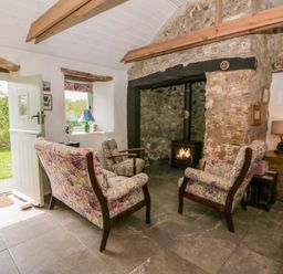 A living room with a fireplace and seating area at Rhos Y Clegyrn in Goodwick