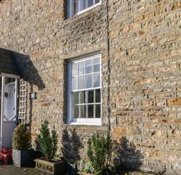 An exterior view of a stone cottage with a window and door at Englewood Cottage Hexham