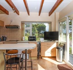A kitchen with appliances and seating at Flat 1 Lee Cliff Park Dawlish Warren