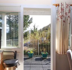 A kitchen view of a balcony with flower pots at Flat 1 Lee Cliff Park in Dawlish Warren