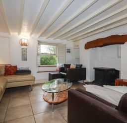 A living room with a sofa and table at Plenteth in Truro