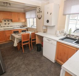 A kitchen with a dining table and chairs at 16 Forth An Nance in Portreath