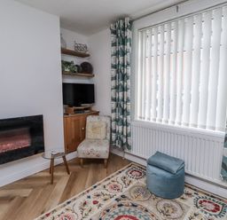 A living room with a fireplace and a TV at 55 Meldon terrace in Newbiggin-by-the-Sea