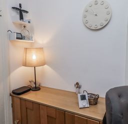 A hallway with a lamp and clock on a wooden cabinet at 55 Meldon terrace Newbiggin-by-the-Sea