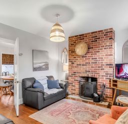 A living room with a sofa and television at Bay Tree Cottage in Heacham