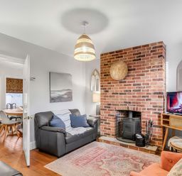 A living room with a fireplace and television at Bay Tree Cottage in Heacham