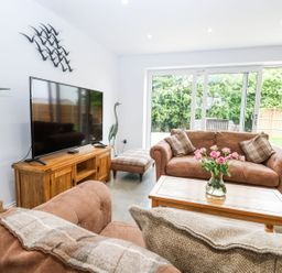 A living room with a sofa and TV at The Ivy in Norwich