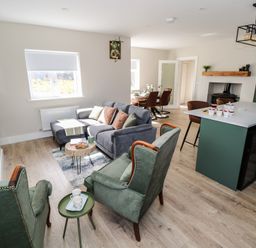 A living room with a sofa and coffee table at Doire Fhatharta Beag in Carraroe, County Galway