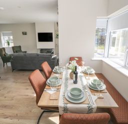 A dining room with a table set for a meal at Doire Fhatharta Beag, Carraroe, County Galway