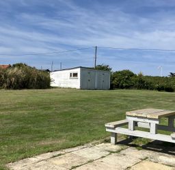 A garden with a table and a shed at Seadrift Bush Estate near Happisburgh