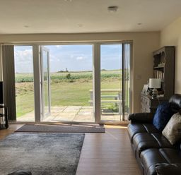 A living room with a sofa and television at Seadrift Bush Estate near Happisburgh