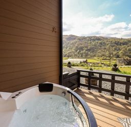 A hot tub on a deck with a view of mountains at Bluebelle - Crossgate Luxury Glamping in Hartsop