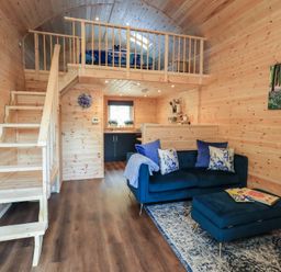A living room with a staircase and sofa at Bluebelle - Crossgate Luxury Glamping Hartsop