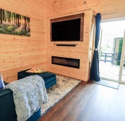 A living room with a sofa and television at Bluebelle - Crossgate Luxury Glamping Hartsop