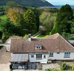 An overview of a house with a patio and garden at Barton Lodge in Porlock