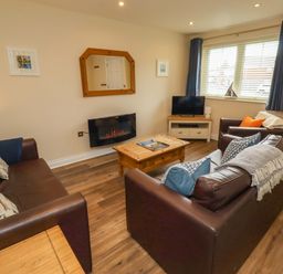 A living room with sofas and a television at 35 Longbeach Drive