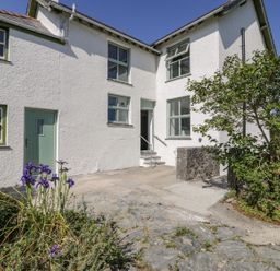An exterior view of a house with plants and a pathway at Ty Mawr Farm in Llanfairpwllgwyngyll