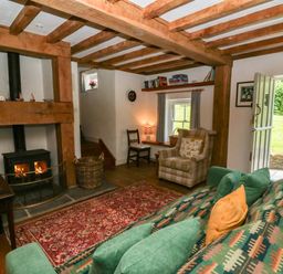A living room with a fireplace and sofa at Cynefin, Newport, Pembrokeshire