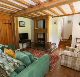 A living room with a sofa and fireplace at Cynefin in Newport, Pembrokeshire