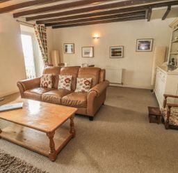 A living room with a sofa and coffee table at Shepherds Nook in Chathill