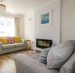 A living room with a sofa and wall art at Seahorses in Padstow