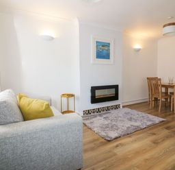 A living room with a sofa and dining table at Seahorses in Padstow