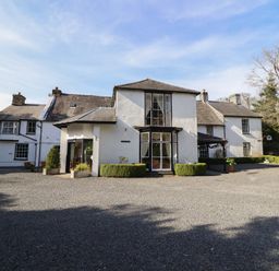 A house with a gravel parking area at Plas Dolguog Machynlleth