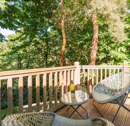 A deck with chairs and a table at Fern View -Kelling Heath Holiday Park, Weybourne near Sheringham